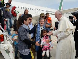 Pope Francis welcomes a group of Syrian refugees to Rome after their plane lands. (AFP/Filippo Monteforte)