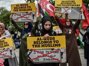 Women protestors hold placards reading "Al Quds belongs to the Muslims" /AFP
