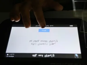 A voting official checks the message on the voting machine, which reads in Arabic "Voting time is over, the station is now closed" /AFP