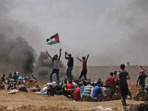 Palestinians wave their national flag as they demonstrate near the border between Israel and the Gaza Strip /AFP