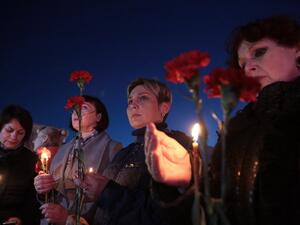 Women hold flowers and lit candles as they take part in a gathering in memory of victims of the blast in the Saint Petersburg metro in Simferopol, Crimea, on April 3, 2017. (AFP/Max Vetrov)