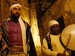 An Arab-Israeli Christian man carrying out the role of a "Musaharati", the traditional figure who awakens Muslims for the "Suhur",  walks in the street rousing Muslim residents in the northern Israeli port city of Acre. (AFP/File)