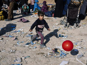 A displaced Iraqi boy, who fled the violence in the Islamic State (IS) group stronghold of Mosul, plays with a ball as he waits for transportation to IDP camps near the town of Bartella (Dimitar DILKOFF / AFP)