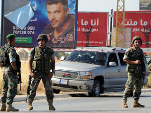 Lebanese soldiers stand guard at the site of a car bomb attack that hit a Hezbollah convoy travelling towards the Lebanese border crossing with Syria, on the Majdal Anjar-Masnaa road on July 16, 2013. (Source: AFP/STR)