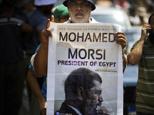 A man holds a portrait of ousted president Mohamed Morsi as thousands of his supporters demonstrate for his reinstatement close to the Egyptian cabinet headquarters on July 17, 2013 in Cairo. (Source: AFP/GIANLUIGI GUERCIA)