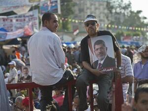 A man holds a portrait of deposed president Mohamed Morsi during a rally in his support outside Rabaa al-Adawiya mosque in Cairo (AFP/KHALED DESOUKI)