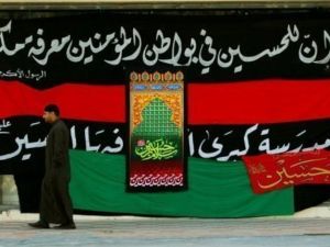 سعودي يمر امام لافتة شيعية في شرق المملكة
