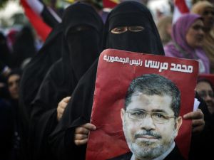 An Egyptian woman holds the portrait of deposed president Mohammed Morsi during a rally in his support outside Rabaa al-Adawiya mosque on July 15, 2013 in Cairo. (Source: AFP/GIANLUIGI GUERCIA)