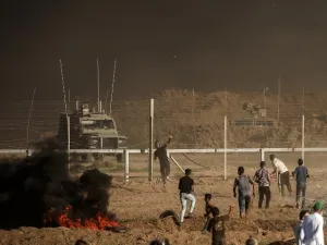 Palestinian protesters throw stones towards Israeli forces during a demonstration along the border between Israel and the Gaza strip, east of Gaza city on July 27, 2018. (MAHMUD HAMS / AFP)