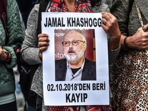 A woman holds a portrait of missing journalist and Riyadh critic Jamal Khashoggi. (AFP/File)