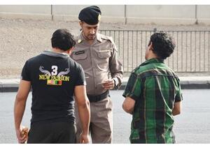 A policeman checks the permits of residents in Saudi Arabia. (Arab News)