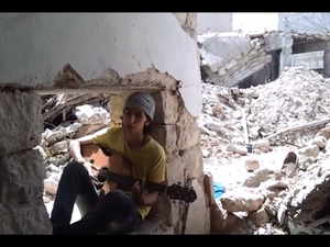 A young Syrian sings in the midst on being targeted by bombs. (YouTube image grab)