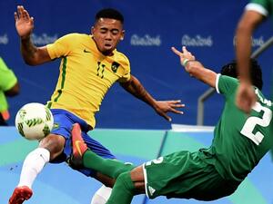 Brazil's player Gabriel Jesus (L) and Iraq's Dhurgham Ismael vie for the ball during their Rio 2016 Olympic Games Men's First Round Group A football match, at the Mane Garrincha Stadium in Brasilia on August 7, 2016.
EVARISTO SA / AFP
