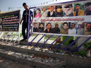 An Iraqi man walks past a poster bearing the portraits of the victims at a cafe, that was popular with local fans of Spain's Real Madrid football club, in the Balad area, north of the capital Baghdad, on May 14, 2016, a day after a deadly raid claimed by Islamic State group militants. At least 16 people were killed and 30 wounded, including several members of the security forces, in the attack in the town of Balad and the ensuing chase, officials said.
AHMAD AL-RUBAYE / AFP