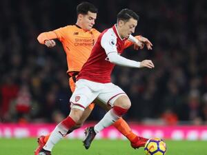 صراع على الكرة بين أوزيل (يمين) وكوتينيو