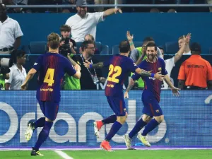لاعبو برشلونة يحتفلون بهدف ميسي (يمين)