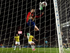 جيرارد بيكيه مدافع برشلونة يحاول إبعاد الكرة التي جاء منها هدف كولومبيا الأول