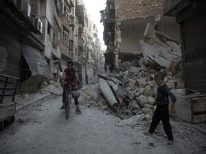 Aleppo residents walk through the rubble of the regime-controlled neighborhood of Karm al-Jabal after an airstrike on September 18, 2016. (AFP/Karam Al-Masri)