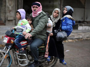 A Syrian family ride a motorbike in the town of Saqba, on the outskirts of the capital Damascus. (AFP/AMER ALMOHIBANY)