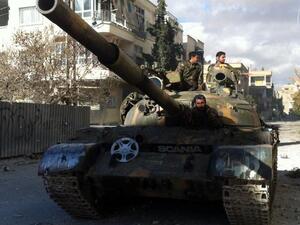 Syrian pro-government forces patrol in their tank in the town of Nabak near Damascus on December 7, 2013. [AFP]