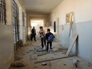 Syrian children search for their belongings at a school following airstrikes by Syrian government forces on December 22, 2013 in the northern Syrian city of Marea on the outskirts of Aleppo. [AFP]