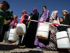 Syrian-Kurdish refugee women wait to fill up water containers at the Quru Gusik (Kawergosk) refugee camp, 20 kilometers east of Arbil, the capital of the autonomous Kurdish region of northern Iraq. [AFP]
