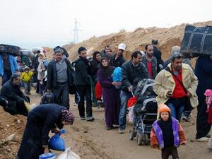 Residents of the industrial city of Adra, northeast of Damascus, walking as they are evacuated from the city, which is strategically located on a main road into the capital, due to fierce fighting between government troops and opposition forces. [AFP]