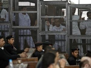 Detained Al Jazeera journalists on trial at an Egyptian court in January 2015.  The journalists, Australian Peter Greste, Egyptian-Canadian Mohammad Fahmy, and Egyptian Baher Mohammad, were held on charges including spreading false news and aiding a terrorist organization.  (AFP/Khaled Desouki)