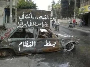سيارة محترقة في بانياس وعليها شعارات تطالب باسقاط النظام