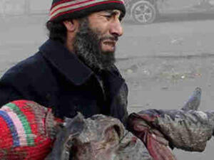A Syrian man cries carrying the body of a child killed by a barrel bomb. [gendynamics]