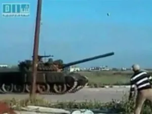 رجل يلقى حجرا على دبابة مارة في درعا يوم الاثنين 
