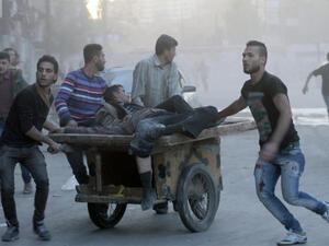 Two injured men are transported on a fruit barrow in the Syria, following a shelling. (Image credit: AFP)