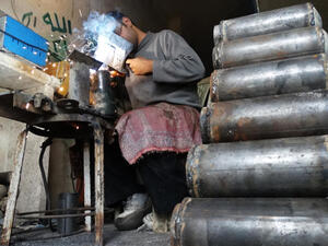 A rebel fighter prepares improvised mortar shells at a workshop in Syria. (Image credit: AFP)