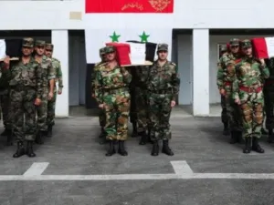 جنود سوريون يشيعون جثامين زملاء لهم في الجيش قتلوا خلال المواجهات 