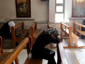 Women pray in a church in Syria. A Syriac Catholic priest was kidnapped along with a companion near Qaryatayn, in Homs governorate, says an NGO. (AFP/Louai Beshara)