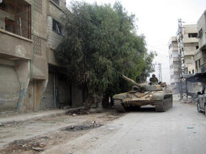 A picture taken on November 7, 2013, shows a pro-regime tank driving through the streets of Sbeineh south of Syrian capital Damascus. (Image credit: AFP)