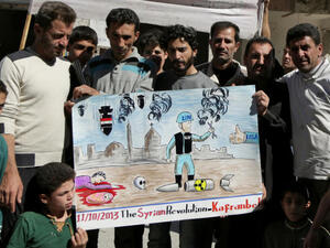 Syrian anti-government protestors hold a poster depicting a inspector from the Organisation for the Prohibition of Chemical Weapons (OPCW). (Image credit: AFP)
