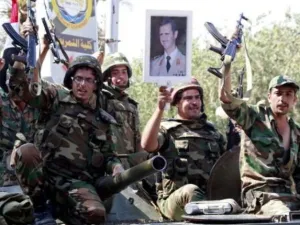عناصر من الجيش السوري يرفعون صورة للرئيس الأسد