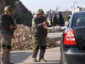 عنصران من الجيش السوري على أحد نقاط التفتيش
