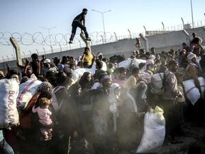 Syrians crossed into Turkey by the thousands as clashes raged last week between Kurdish YPG and Daesh forces in the strategic border town Tal Abyad.  (AFP/Bulent Kilic)
