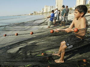 A twelve-year-old boy helps the fisherman in southern Lebanon's port Tyre.  (AFP/Ramzi Haidar)