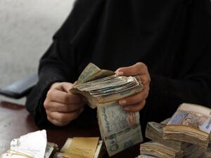 A Yemeni woman holds onto YER (AFP/FILE)