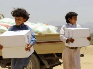 Children carry supplies handed out by UNICEF outside the Yemeni capital Sanaa. Heavy airstrikes and ground fighting across the country have made it extremely difficult for humanitarian aid to reach Yemen's civilians. (AFP/File)