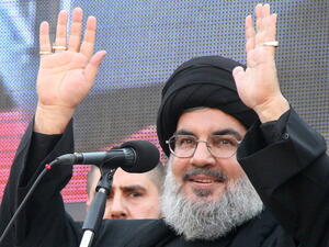 The head of Lebanon's militant Shiite Muslim movement Hezbollah, Hassan Nasrallah greets the audience after speaking during a massive Shiite Muslim commemoration in southern Beirut on November 14, 2013. [Getty Images]