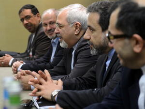 Iranian Foreign Minister Mohammad Javad Zarif attends talks flanked by members of his delegation during talks over Iran's nuclear programme in Geneva on November 22, 2013. [AFP]