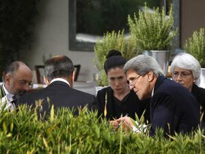 US Secretary of State John Kerry and Russian Foreign Minister Sergei Lavrov (back to camera) meet while seated with their senior aides at a hotel in Geneva on September 14, 2013.  [AFP]