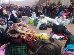 Syrians wait for the arrival of an aid convoy on January 11, 2016 in the besieged town of Madaya as part of a  deal reached in September for an end to hostilities in those areas in exchange for humanitarian assistance. (AFP/Stringer)