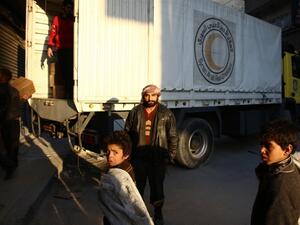 A Syrian man poses in front of a lorry of the Syrian Arab Red Crescent containing aid parcels upon its arrival on February 13, 2016 in the rebel-held city of Douma, northeast of the capital Damascus. (AFP/Abd Doumany)