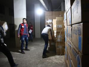 Syrian Red Crescent staff survey the delivery of humanitarian aid in the rebel-held Eastern Ghouta area, on the outskirts of Damascus on Feb. 23, 2016 during an operation to deliver aid to thousands of besieged Syrians. (AFP/Abd Doumany)