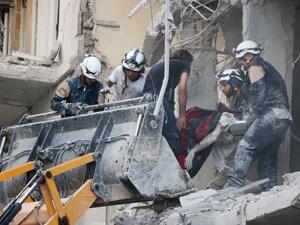 Syrian emergency personnel remove the body of a man from the rubble of a damaged building following reported air strikes on July 7, 2016, in Aleppo's rebel-held neighbourhood of Tariq al-Bab. (AFP/Thaer Mohammed)